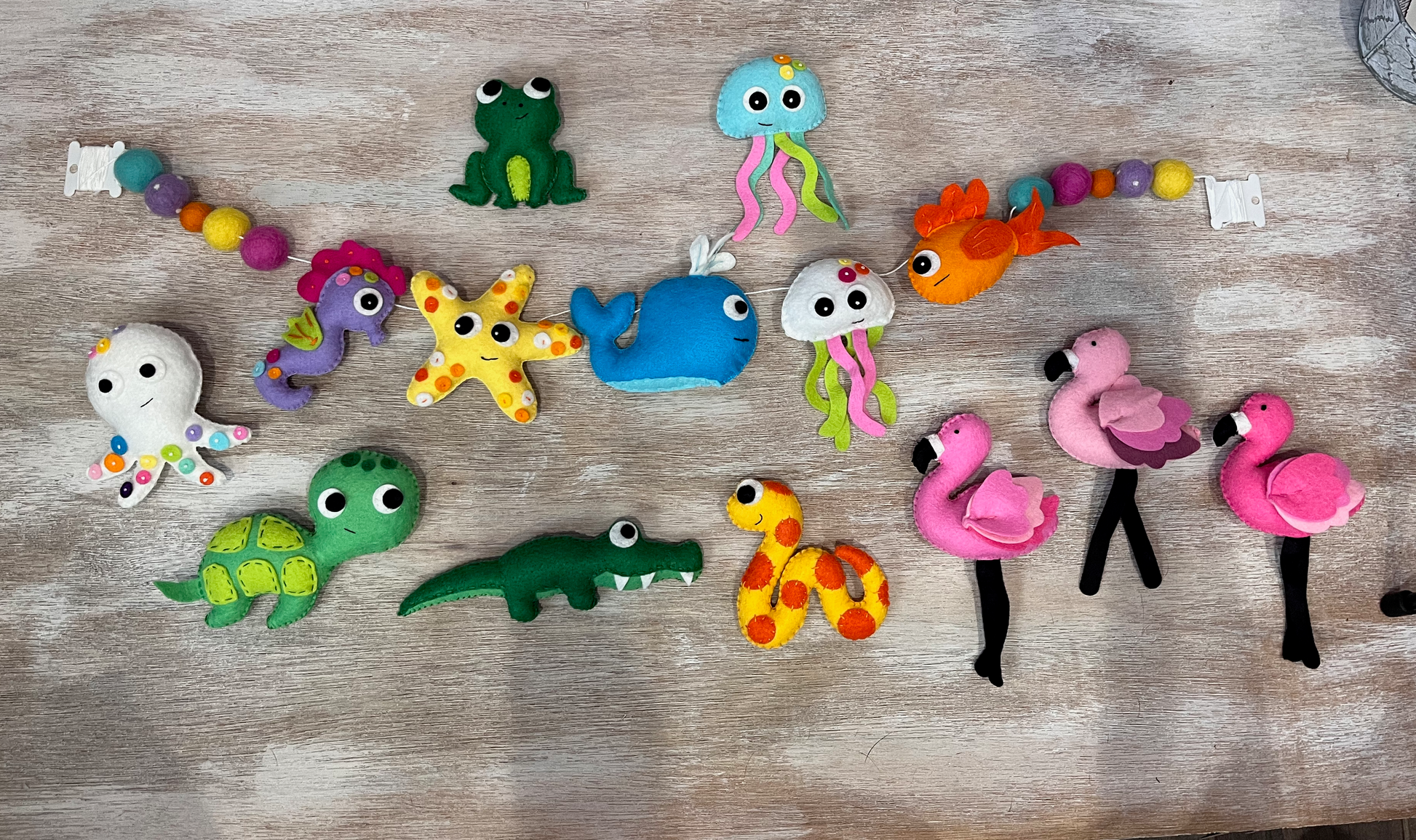 handmade and hand sewn felt creation by a little bit whimsy - brightly colors sea animals/ creatures. primary colors and pastels  snake, octopus, starfish, whale, turtle, crab, nemo fish, frog, seahorse and flamingo. felt garland with felt balls