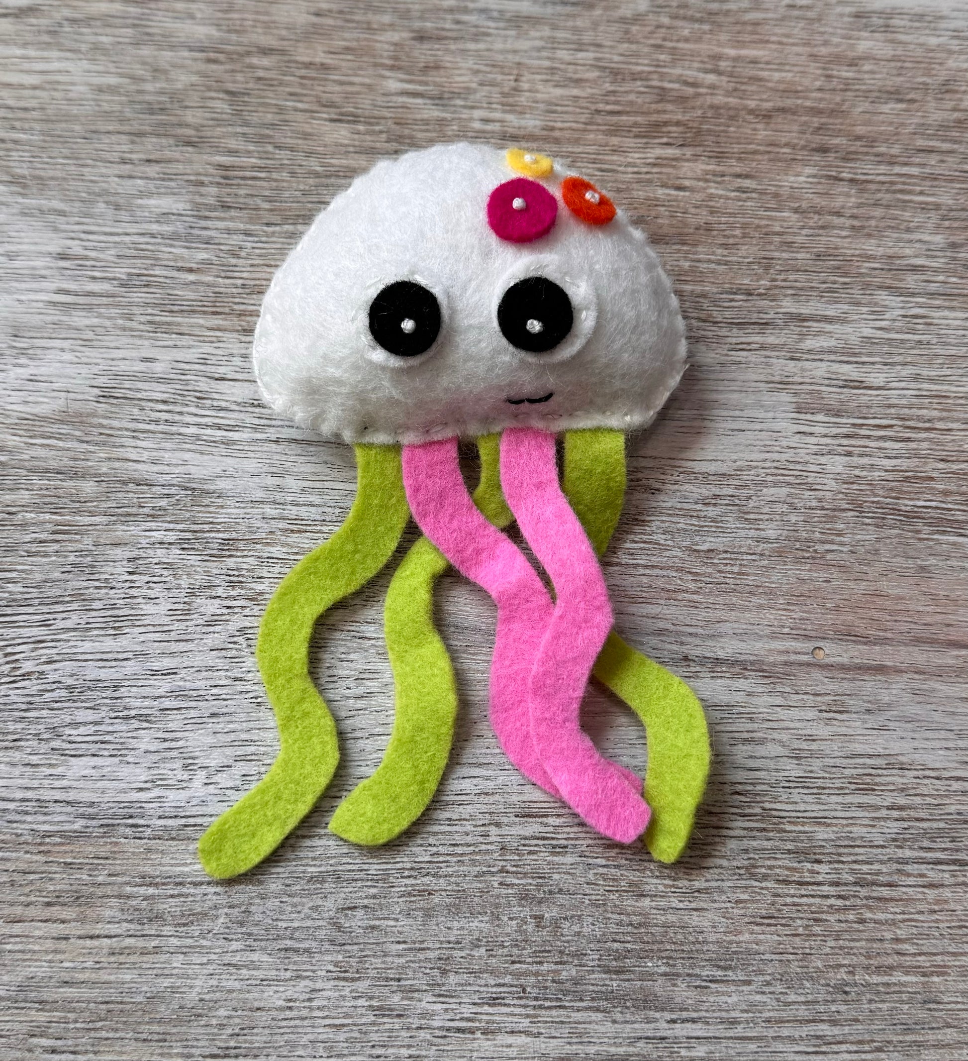 handmade and hand sewn felt creation by a little bit whimsy - brightly colors sea animals/ creatures. primary colors and pastels  smiling white jellyfish