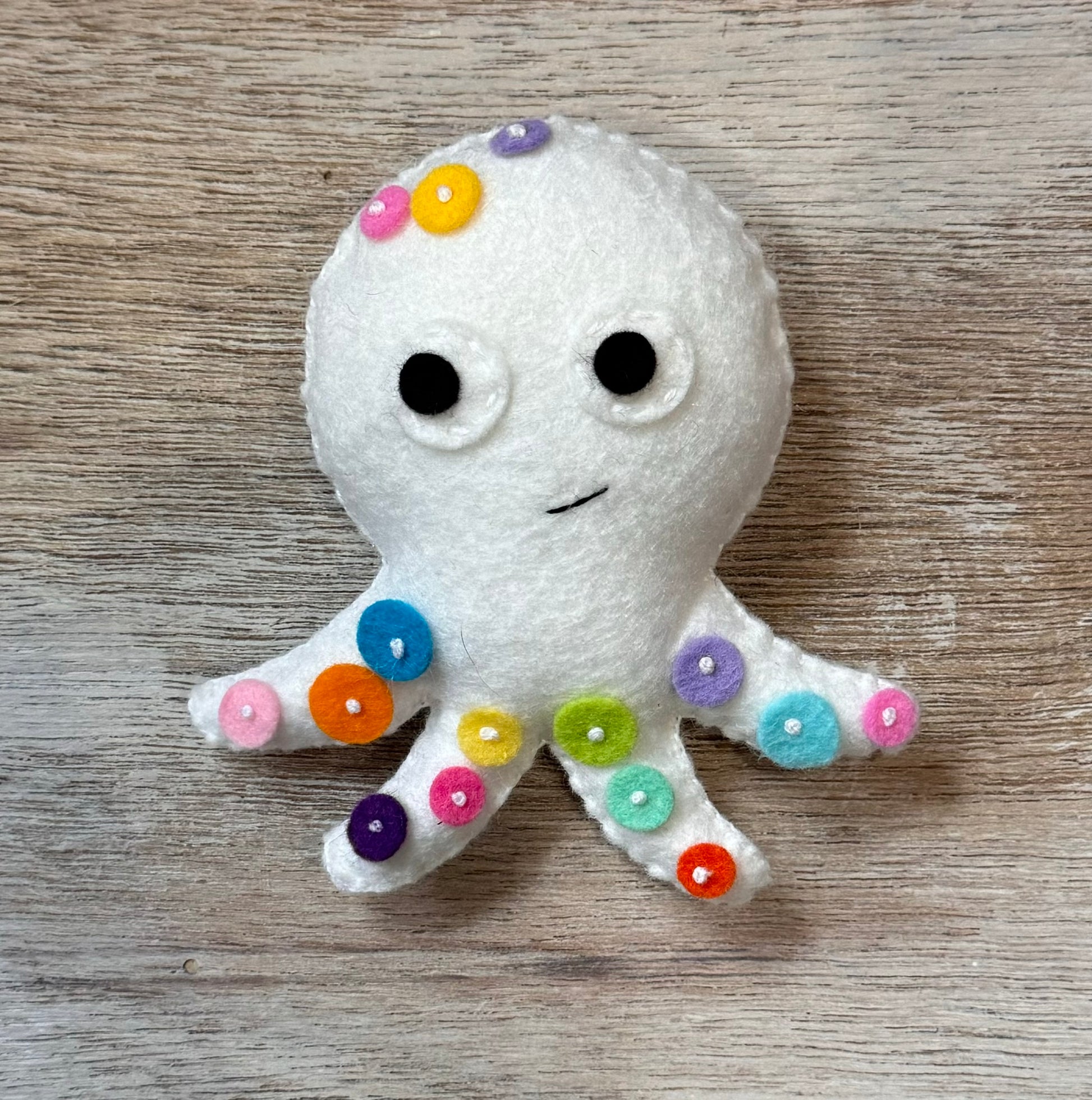 handmade and hand sewn felt creation by a little bit whimsy - brightly colors sea animals/ creatures. primary colors and pastels  smiling white octopus