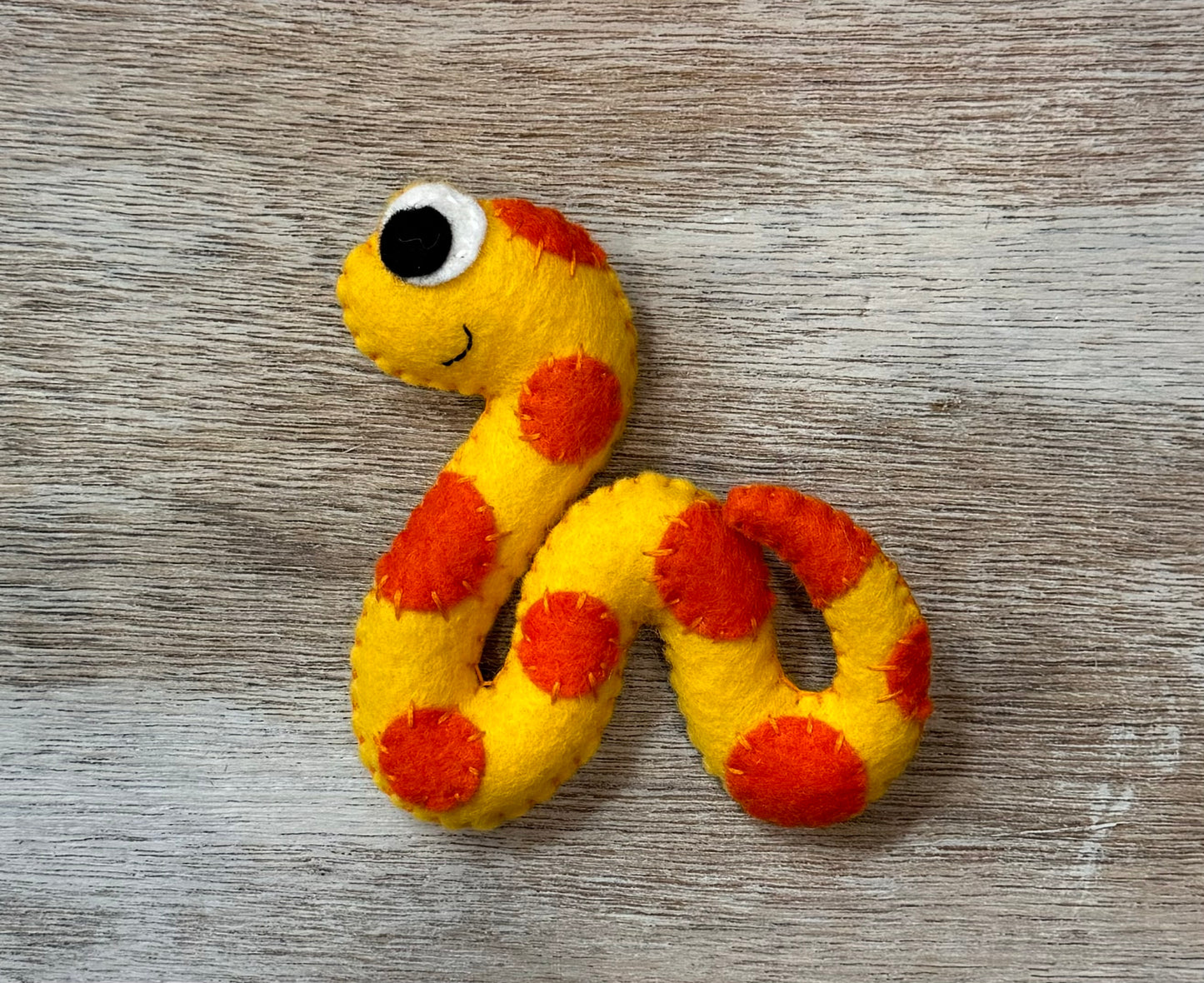 handmade and hand sewn felt creation by a little bit whimsy - brightly colors sea animals/ creatures. primary colors and pastels  smiling orange and yellow snake