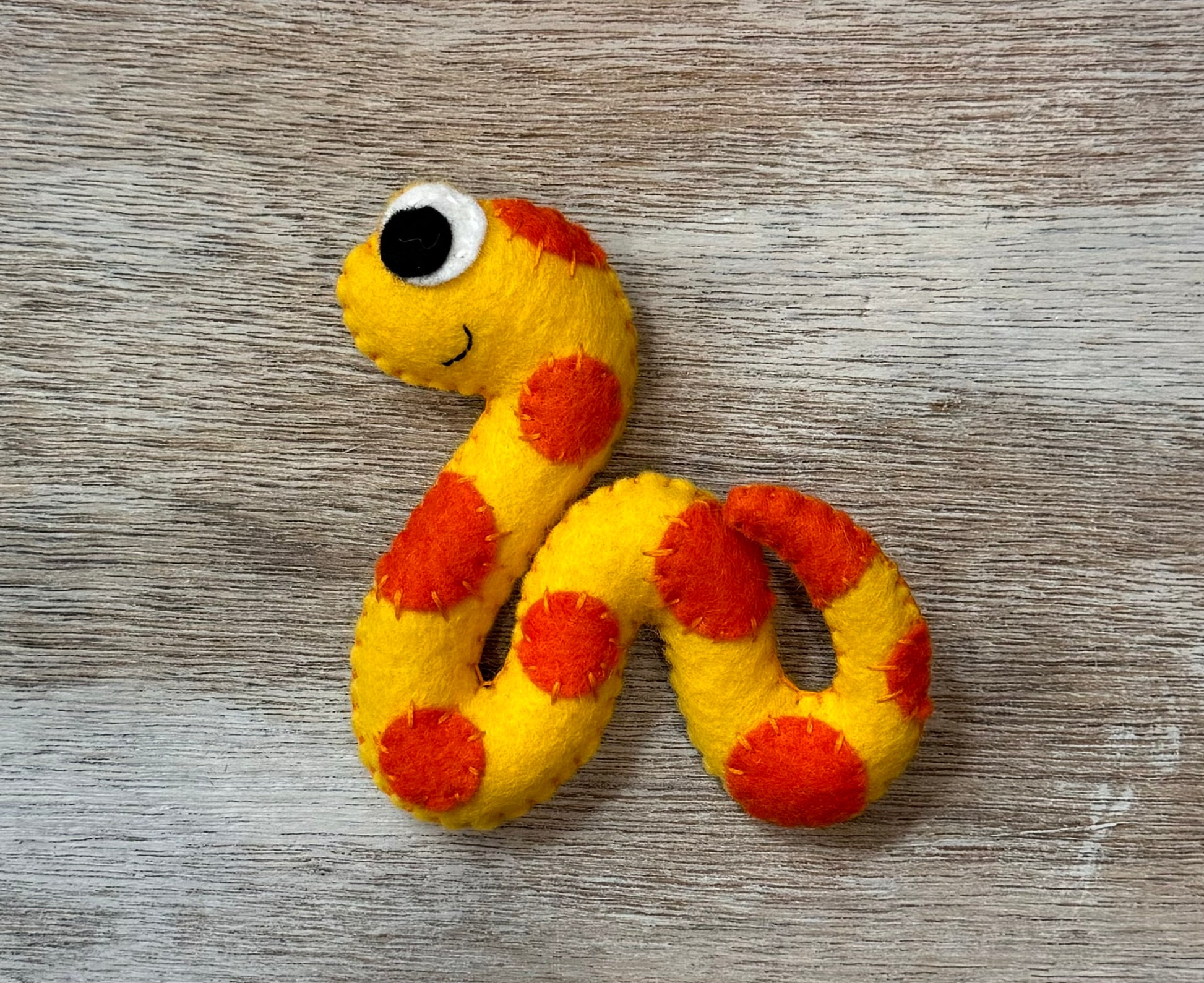 handmade and hand sewn felt creation by a little bit whimsy - brightly colors sea animals/ creatures. primary colors and pastels  smiling orange and yellow snake