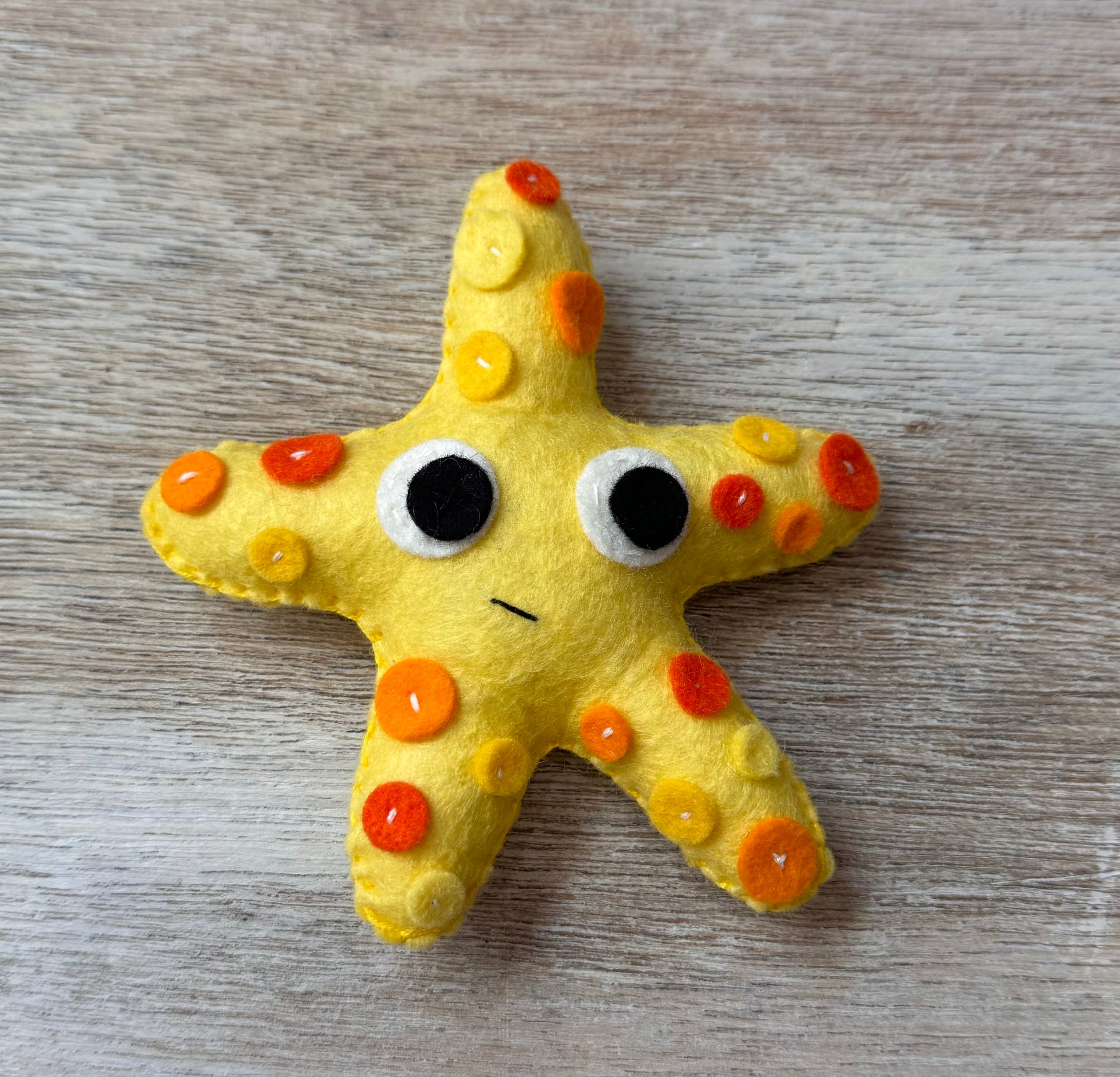 handmade and hand sewn felt creation by a little bit whimsy - brightly colors sea animals/ creatures. primary colors and pastels  smiling orange and yellow starfish